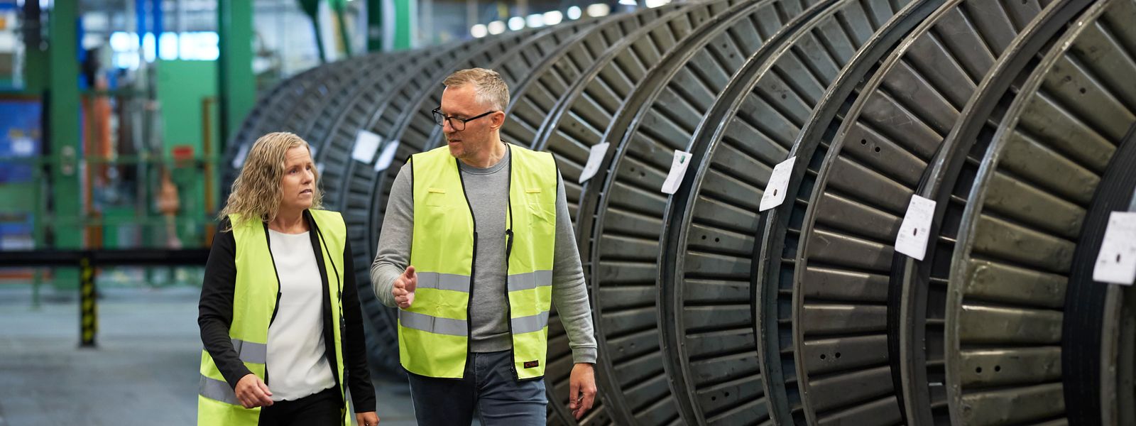 employees discussing and talking in production hall in front of cable drums