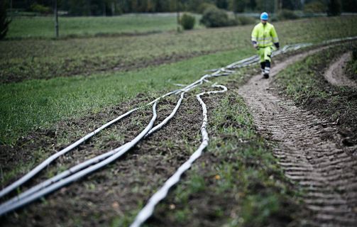 Cable worker walking along a medium voltage cables laying on the ground waiting to be installed